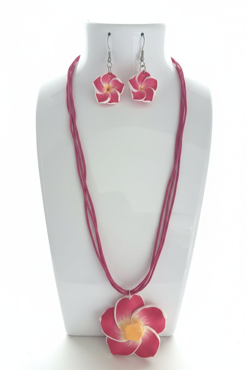 Pink floral necklace and earrings on a white stand.