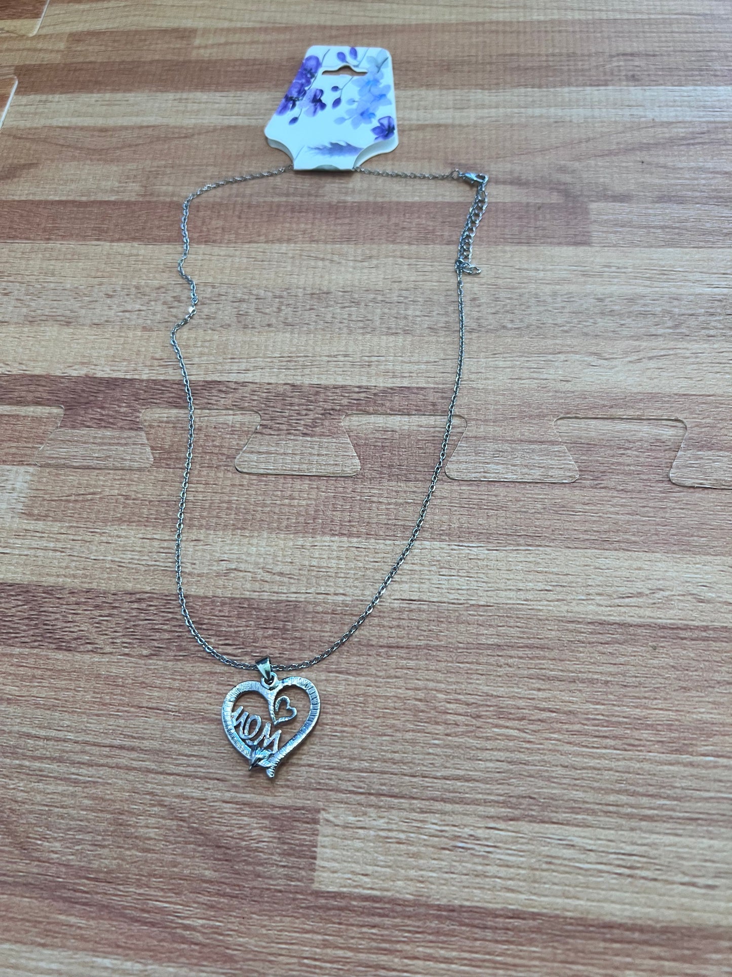 Necklace with a heart-shaped pendant on a wooden surface