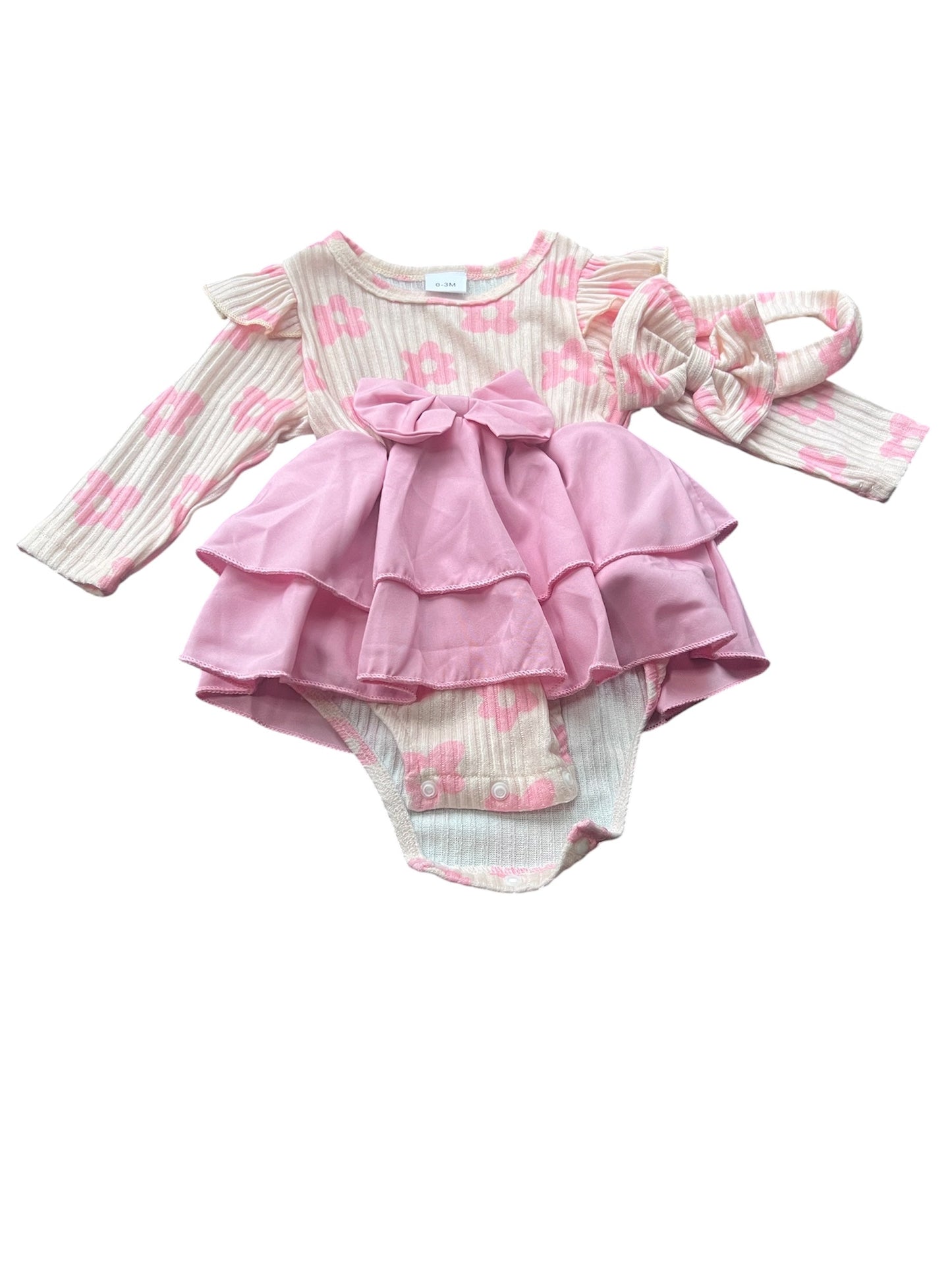 Pink baby outfit with ruffled top and matching bloomers on a white background