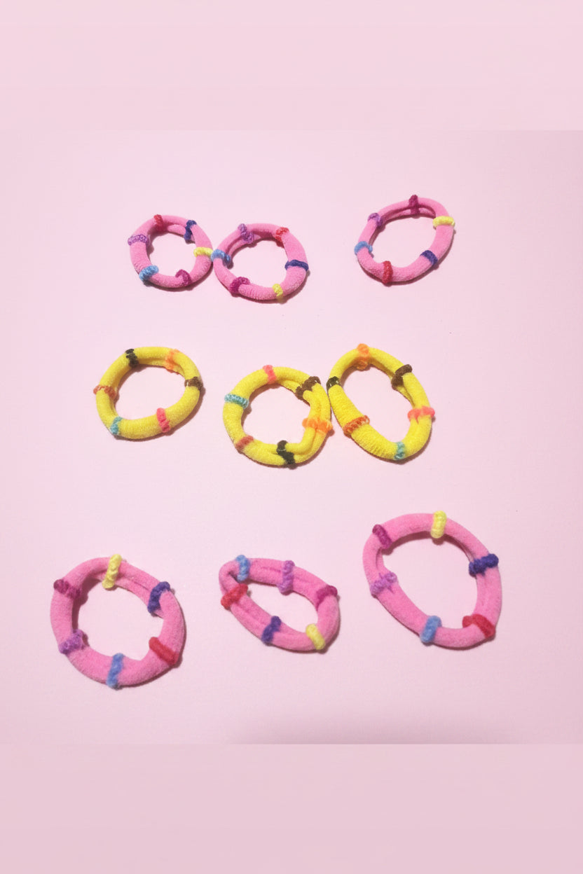Set of colorful hair ties on a pink background