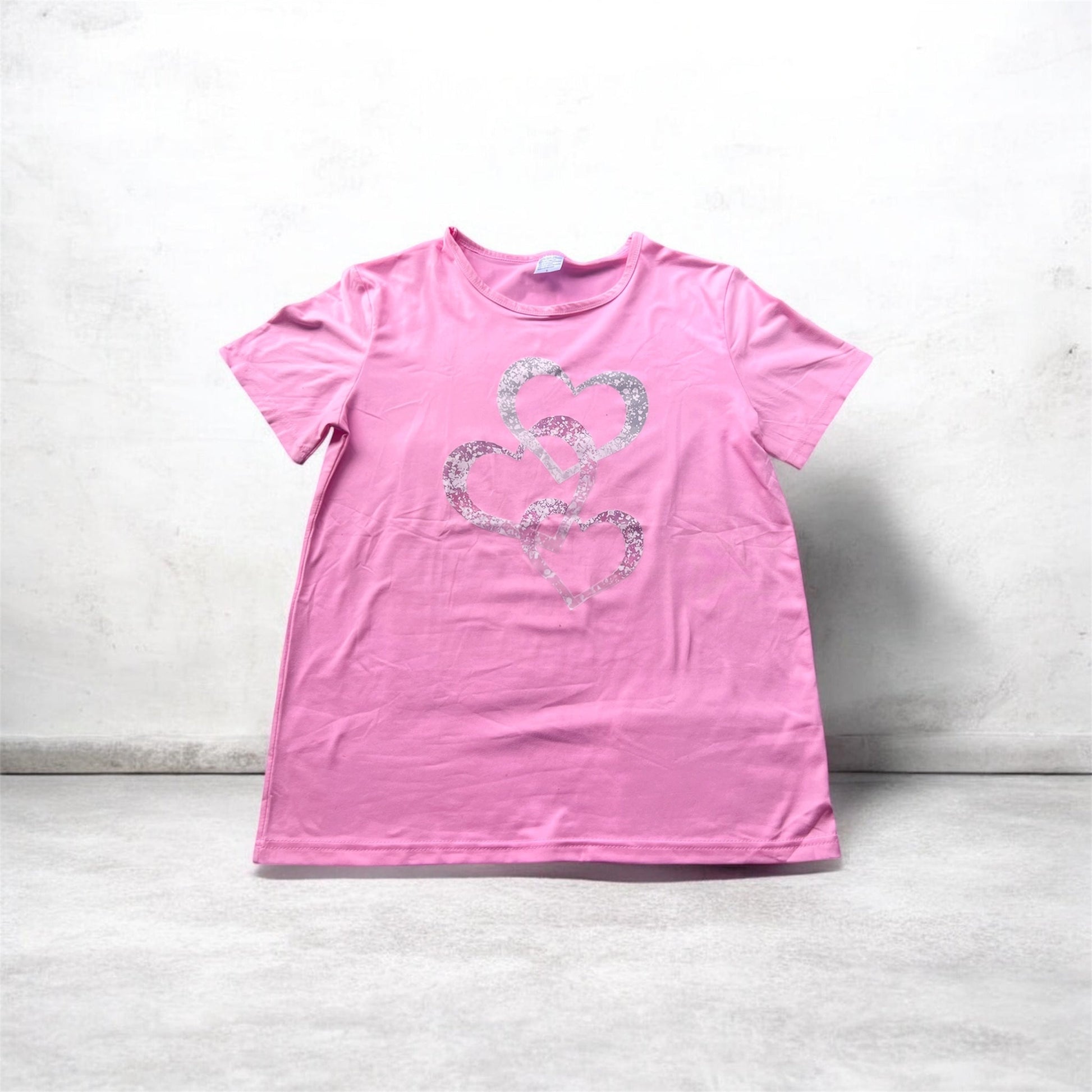 Pink t-shirt with a heart design on a light gray background