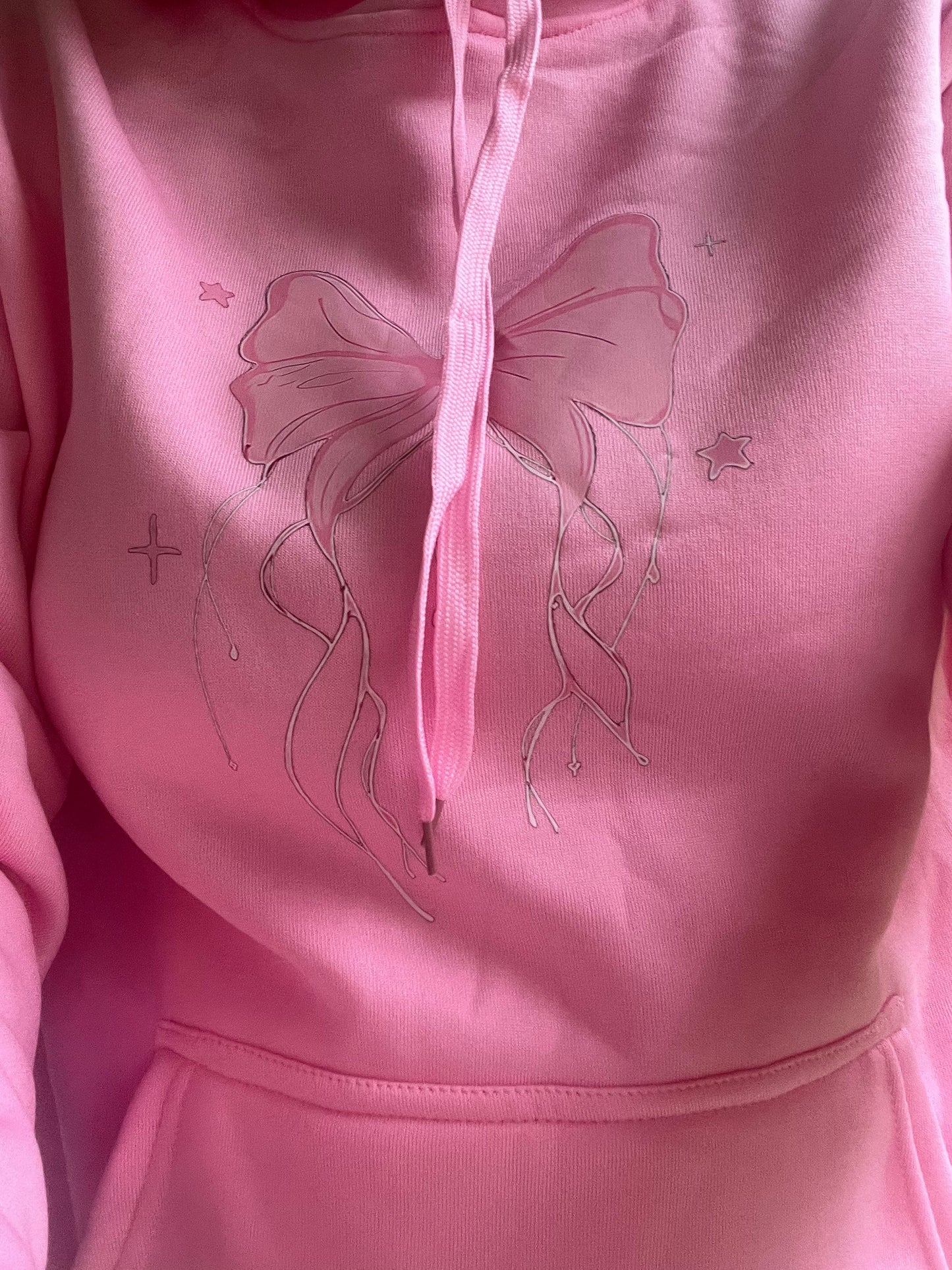 Pink hoodie with butterfly design closes up
