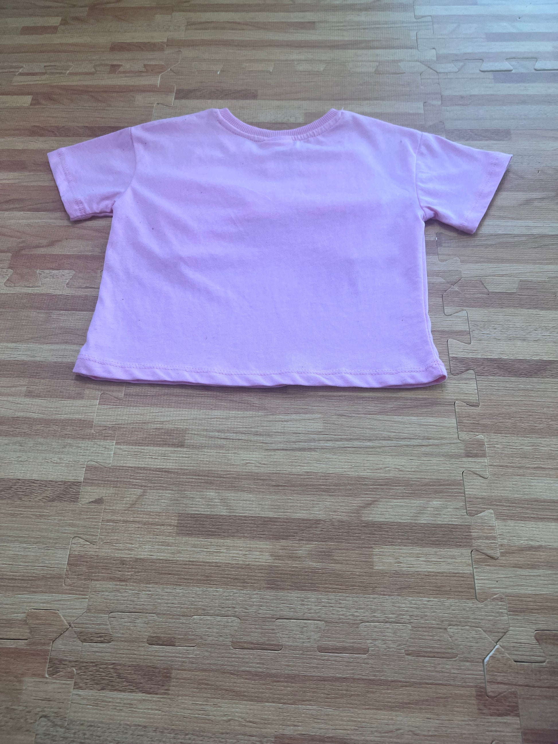 Tee laid flat on floor, back/plain view