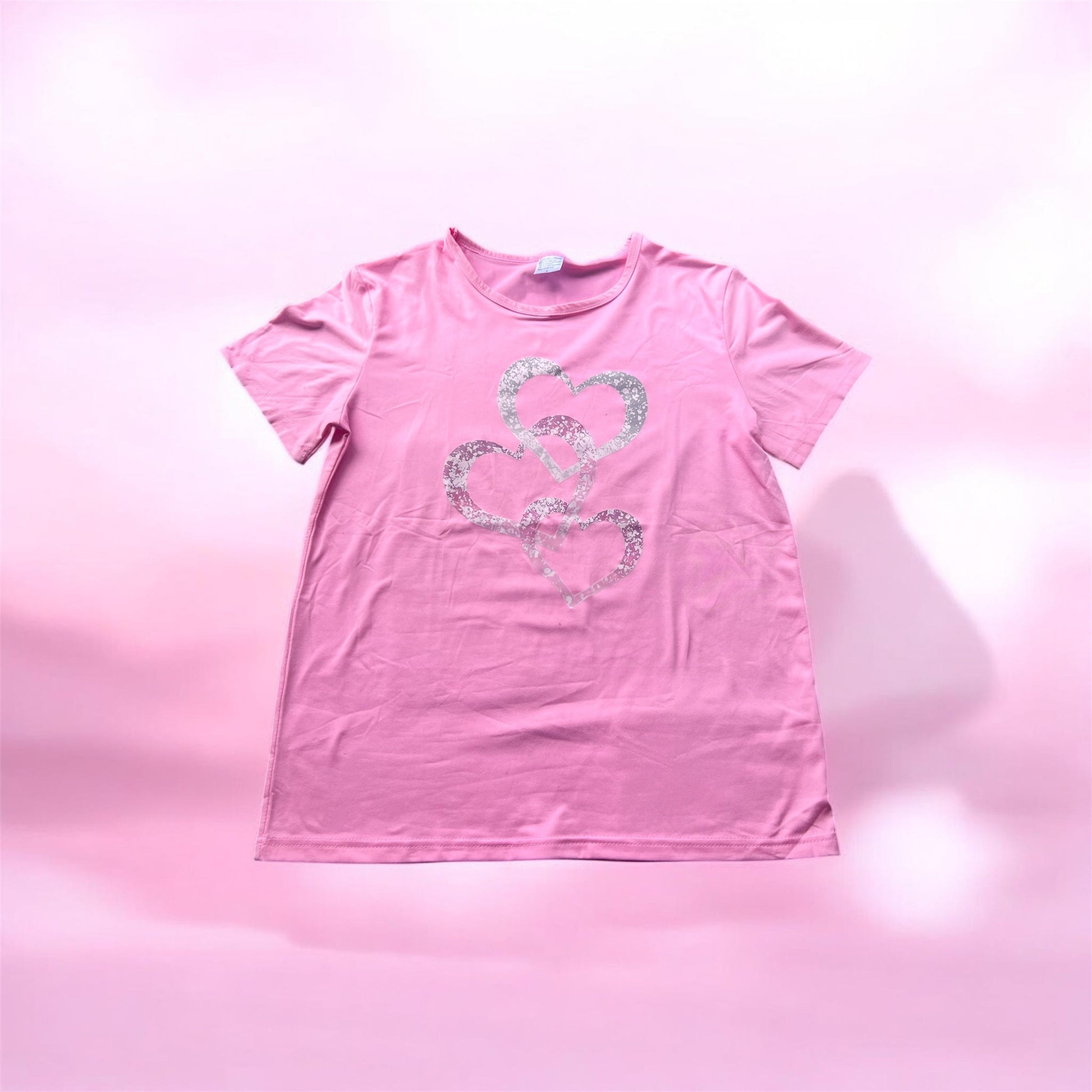 Pink t-shirt with a heart design on a pink background